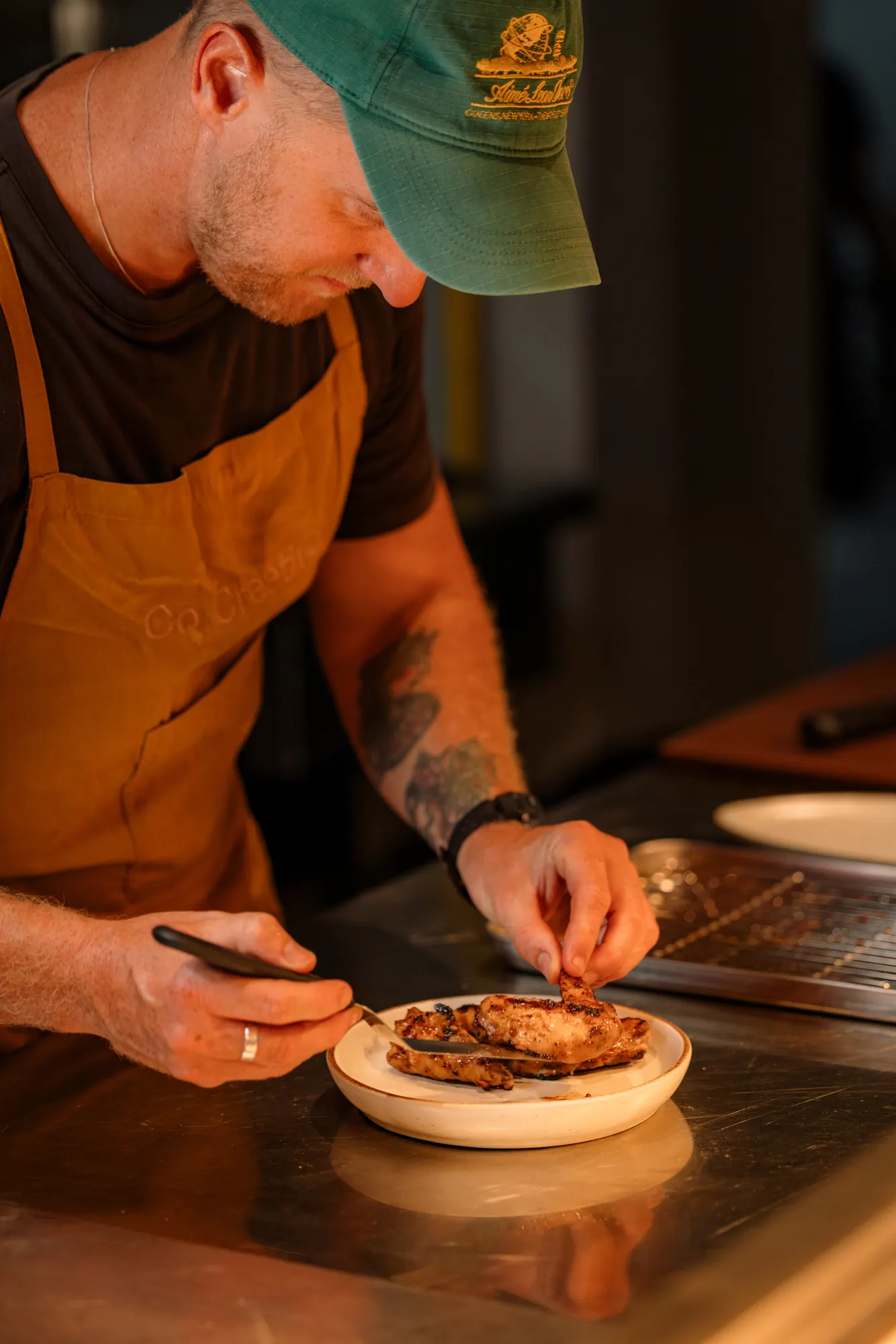 Chef plating grilled chicken at the counter