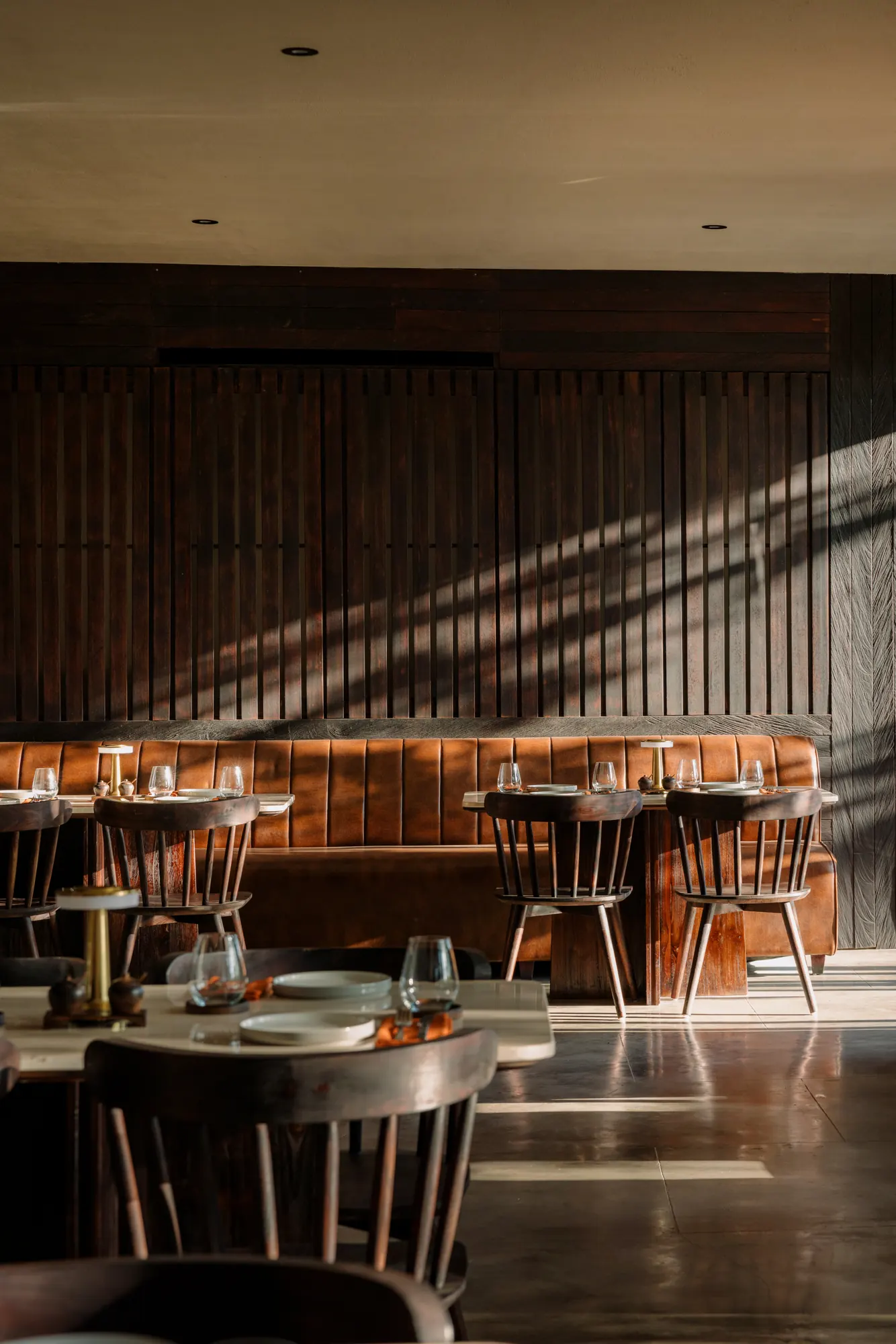 Hibana dining room with a leather banquette in afternoon light